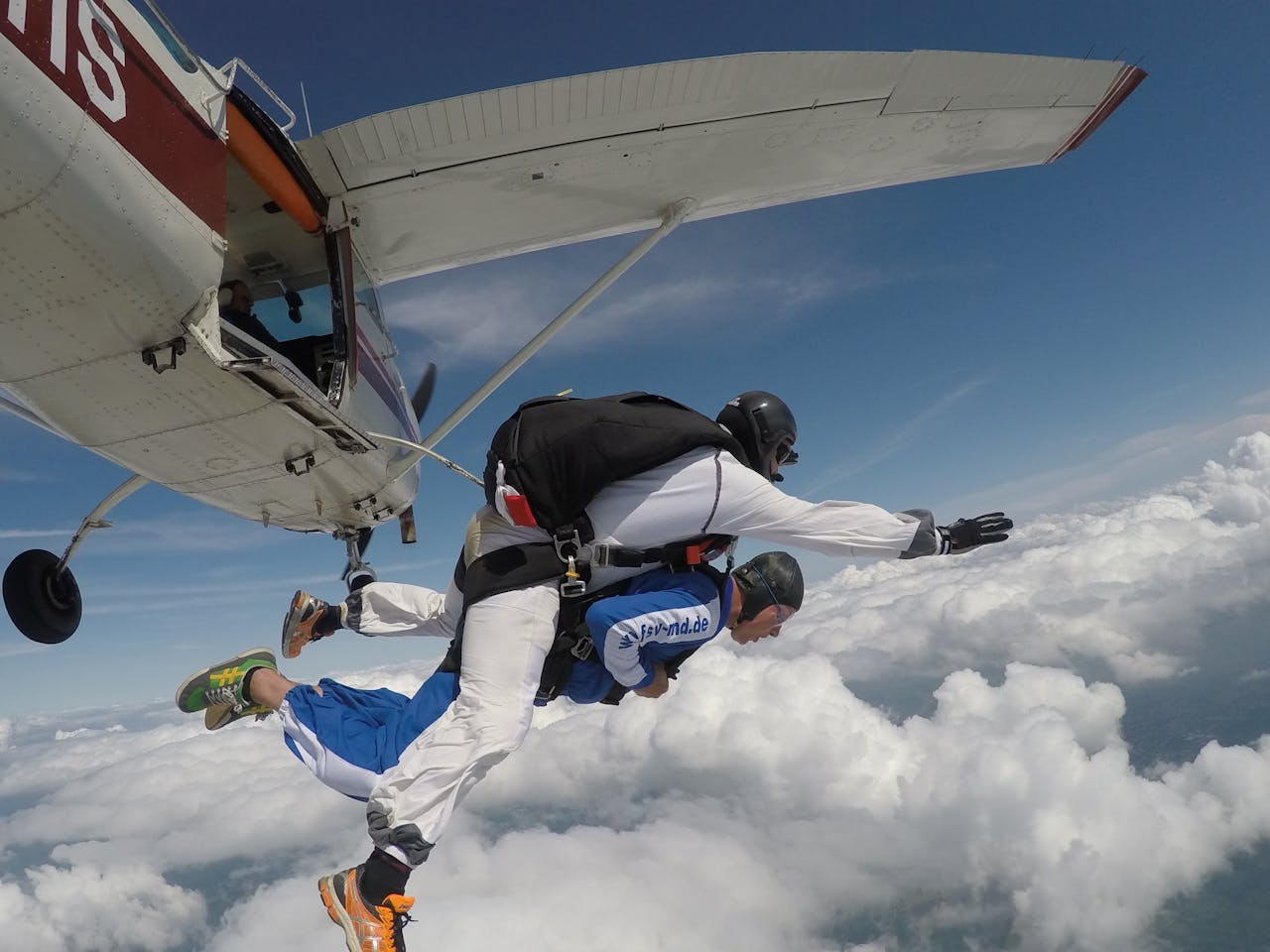 Skydiving: two people jumping out of a white jet.